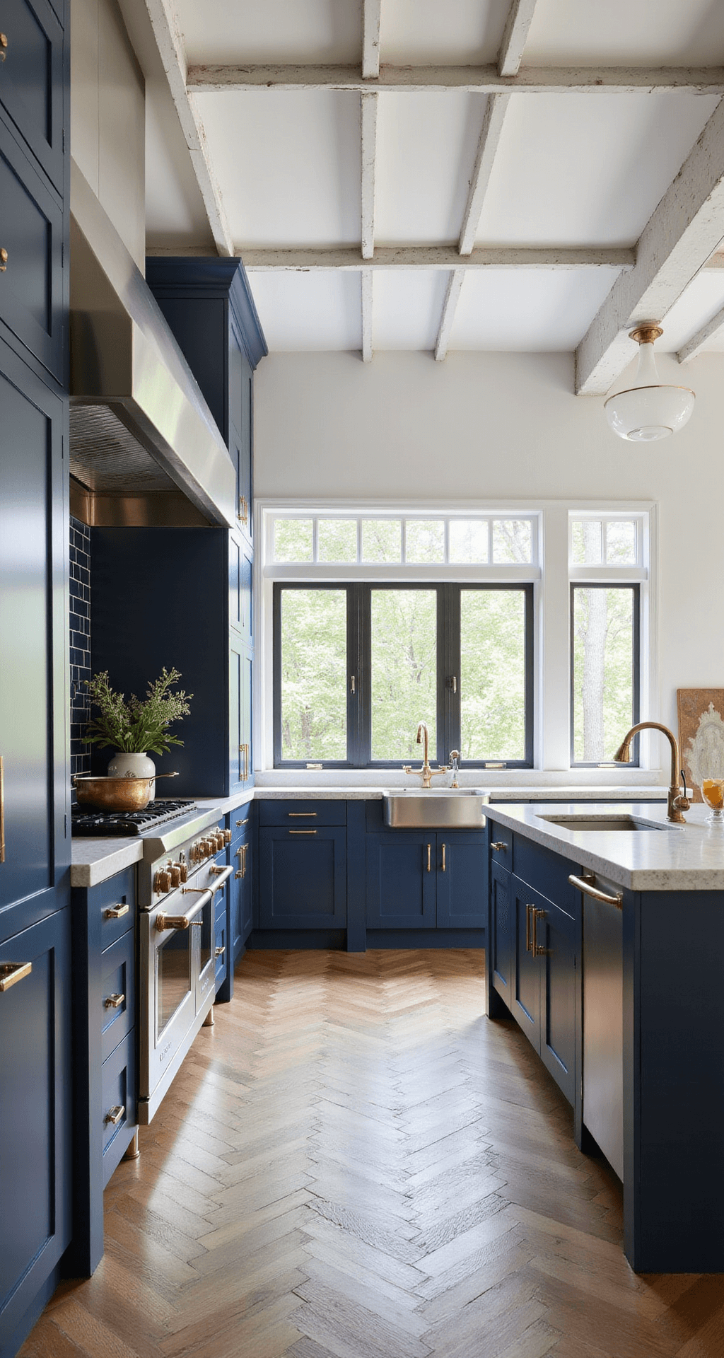 Bright modern French kitchen featuring navy blue cabinets, quartzite countertops, vintage copper pans, and herringbone oak floors, illuminated by natural light from steel-framed windows and a vaulted ceiling with whitewashed beams.